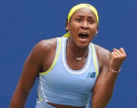 Coco Gauff uśmiechnięta, wchodząca w interakcję z fanami lub podpisująca autografy, ukazująca jej sympatyczną osobowość poza kortem.