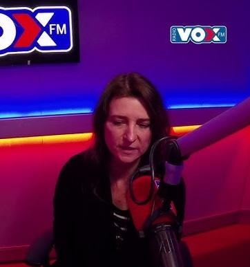 Renata Dąbkowska w dynamicznym ujęciu podczas występu na scenie, śpiewająca do mikrofonu, z nastrojowym oświetleniem koncertowym.