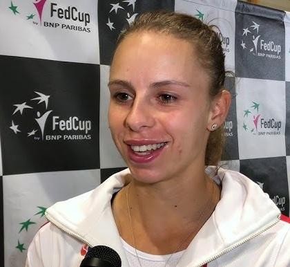 Magda Linette w zbliżeniu, ujęcie dynamiczne na korcie tenisowym, podczas meczu, z widocznym skupieniem i determinacją.