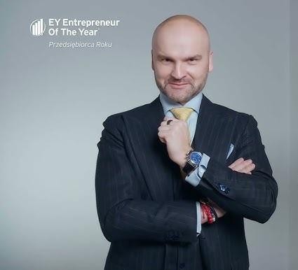 Rafał Brzoska podczas uprawiania sportów ekstremalnych, np. wspinaczki skałkowej, skoków spadochronowych lub wyścigów samochodowych.
