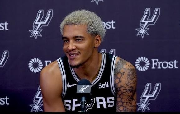 Jeremy Sochan podczas meczu NBA, skupiony na grze, z widocznym charakterystycznym kolorem włosów.