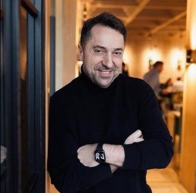Marcin Miller obok luksusowego samochodu, prezentujący swoje zainteresowania motoryzacyjne poza sceną muzyczną.