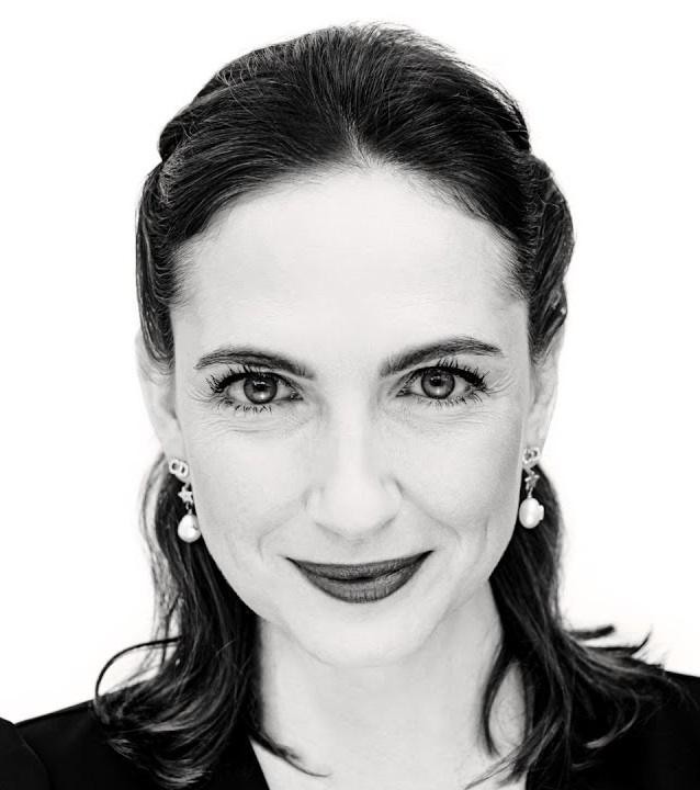 Anna Cieślak w trakcie dynamicznego występu na scenie lub planie filmowym, z ekspresyjną mimiką i gestykulacją.