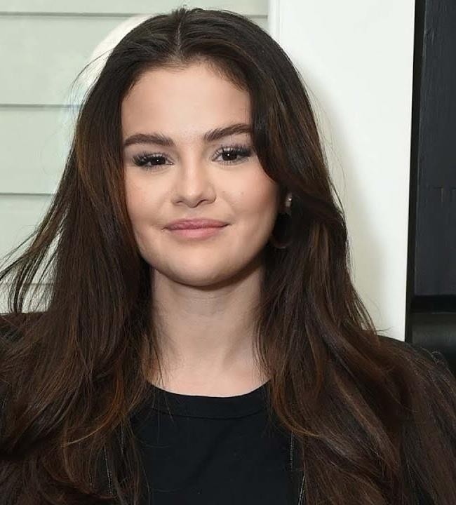Dynamiczne ujęcie Seleny Gomez podczas publicznego wystąpienia lub sesji zdjęciowej, podkreślające jej pewność siebie i elegancję.
